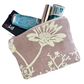 Floral-patterned pouch with lip balm, mints, small handcream and transport card on a white background